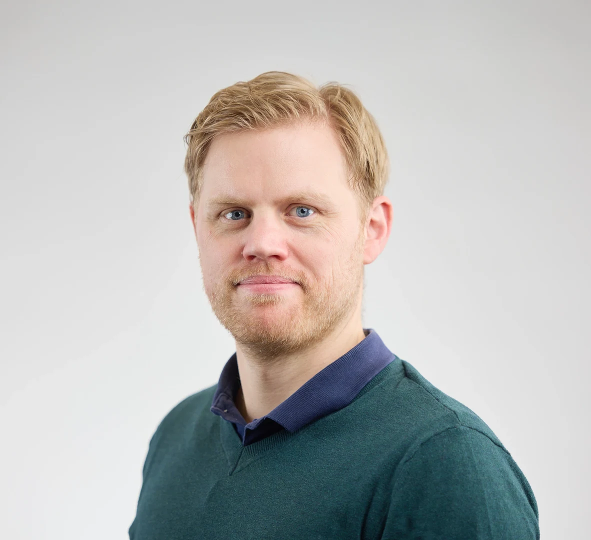 Eine Wissenschaftlerin und ein Wissenschaftler arbeiten hinter einer Glasfassade und mischen Chemikalien mit Großgeräten.